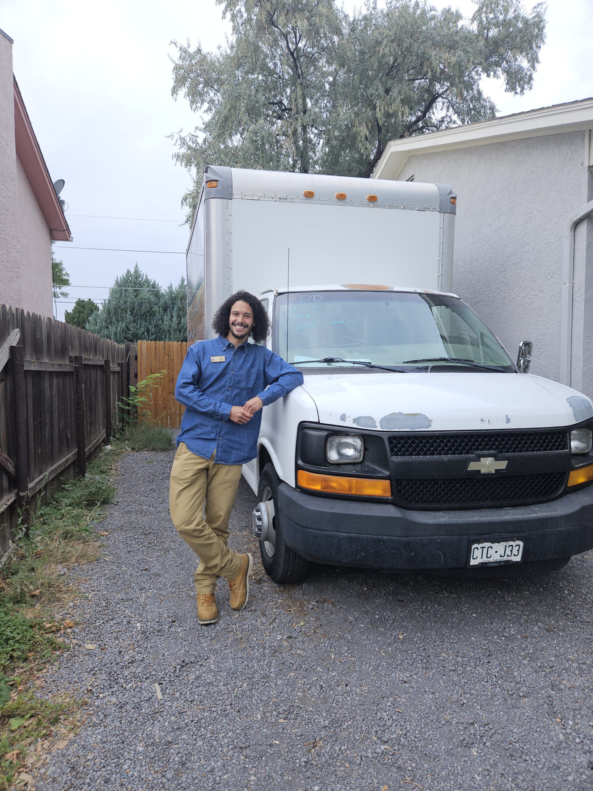 Gino Hyppolite, IICRC-certified owner of All Floors Pueblo LLC, standing in front of his service van in Pueblo CO