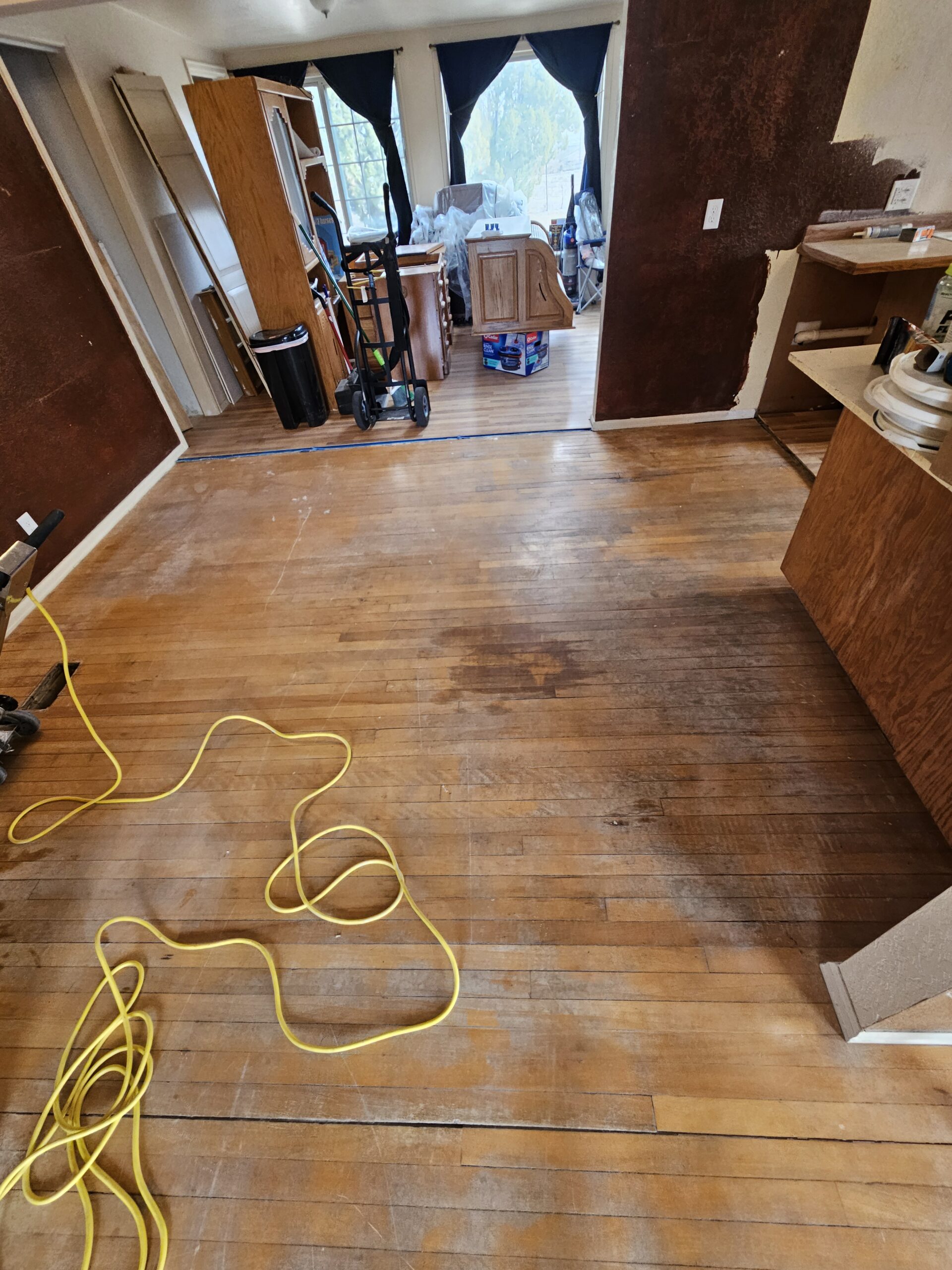 Scratched and water stained hardwood floors before professional refinishing Pueblo CO